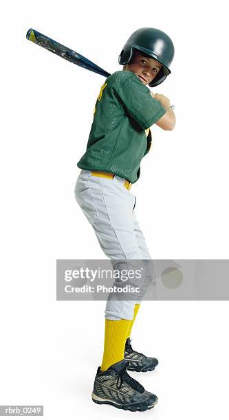 a caucasian male child dressed as a baseball player in a green uniform stands bat raised ready to swing - batting isolated stock pictures, royalty-free photos & images