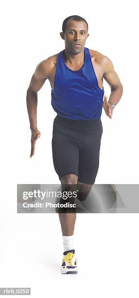 a young african american male runner in black shorts and a blue tank runs forward - running shorts foto e immagini stock