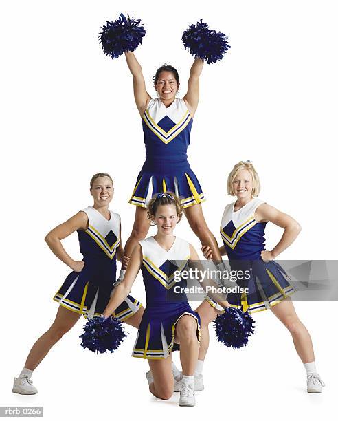 four female cheerleaders wearing blue and white are posing like a triangle while one is lifted up and raises her arms high and holds pom-poms - cheerleader white background stock pictures, royalty-free photos & images