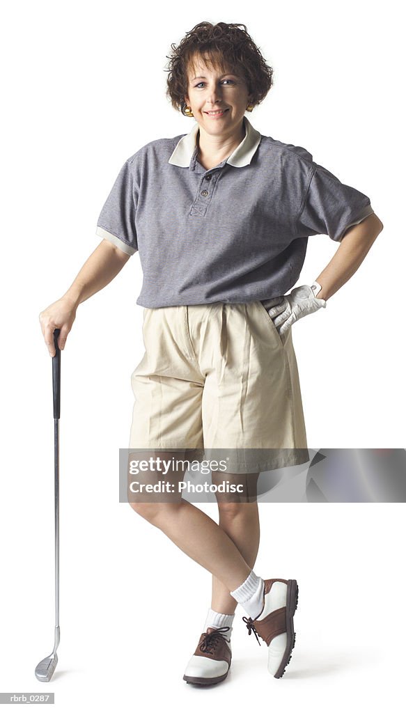 Caucasian middle aged brown haired woman wears gray tan stands hand on hip leans on club and smiles
