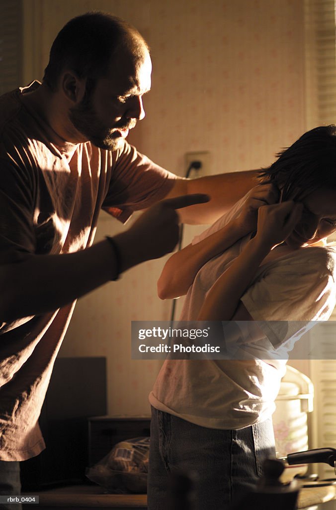 Lifestyle photograph of a young caucasian couple as the man becomes angry and abusive