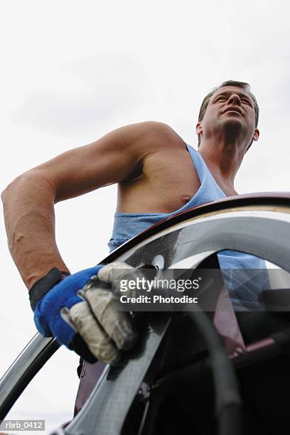 lifestyle photograph of a caucasian male wheelchair racer as he looks off in the distance - carrera de sillas de ruedas fotografías e imágenes de stock