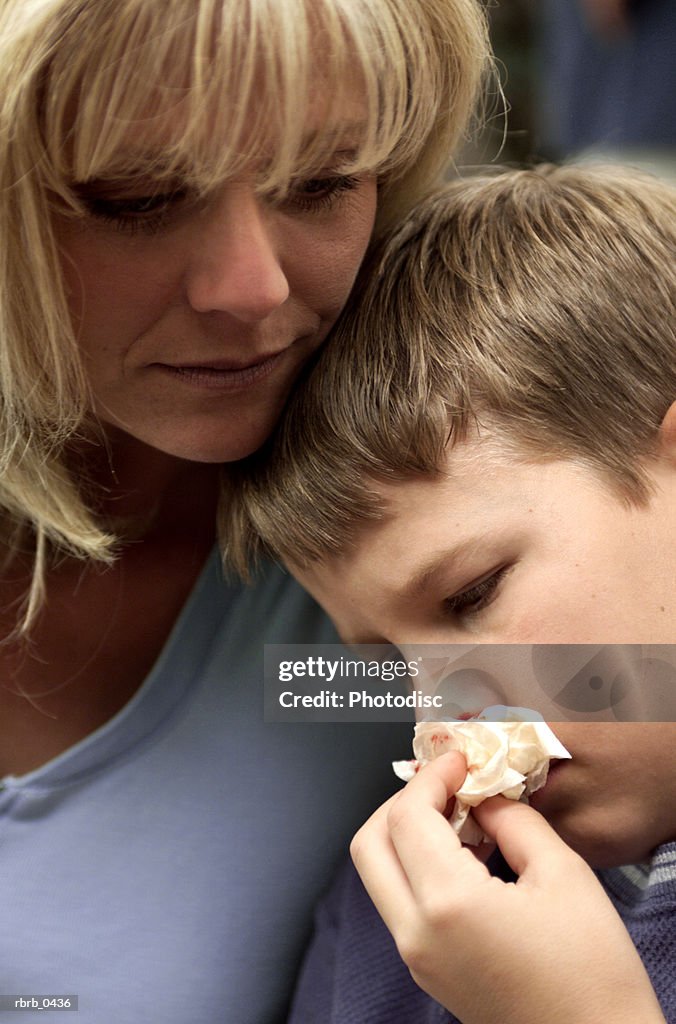 Lifestyle photo of a caucasian mother as she consoles her injured son