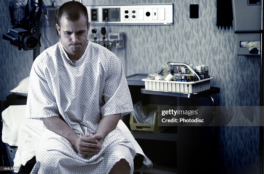 Lifestyle photo of a young caucasian man as he waits in a hospital examination room