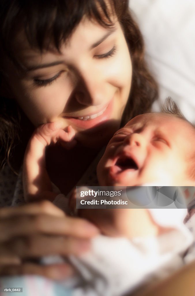Lifestyle photo of a caucasian woman holding her newborn in a hospital room