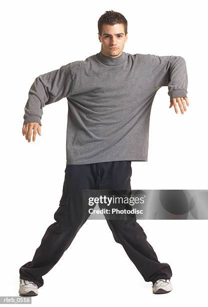 a young caucasian male breakdancer in black pants and a grey shirt as he jumps and dances - breaking habits ストックフォトと画像