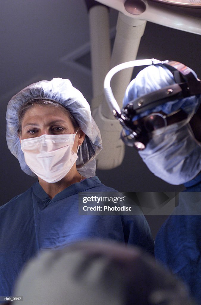 A male surgeon and a female nurse work together during an operation