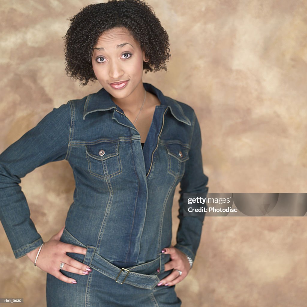 Portrait of a young attractive african american woman in a denim outfit as she flashes some attitude