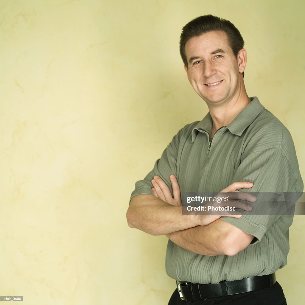 Portrait of an adult caucasian man as he folds his arms and smiles