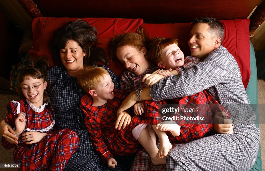 Lifestyle portrait of a caucasian family in their pajamas lying in bed