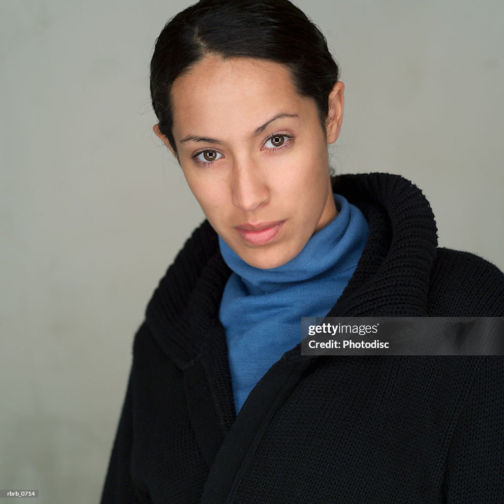 Portrait of a young attractive ethnic woman as she turns and looks seriously into the camera