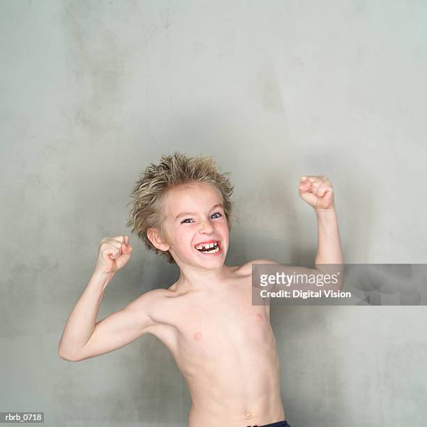 portrait of a caucasian male child with no shirt as he flexes his little arms and smiles - no fotografías e imágenes de stock