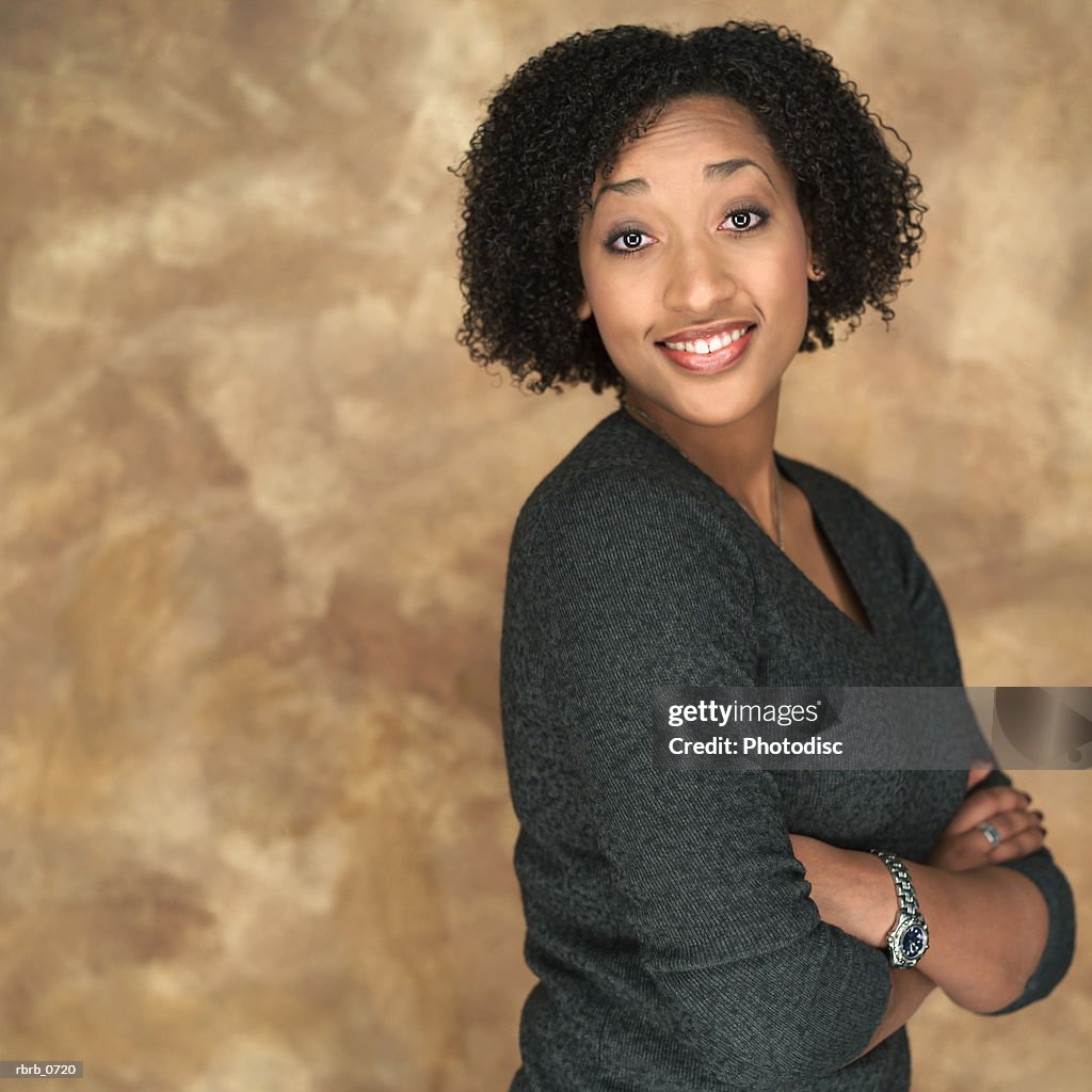 Portrait of a young attractive african american woman as she fold her arms and smiles