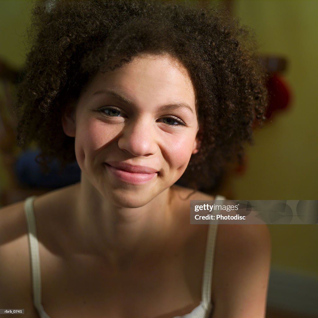 Portrait of an african american teenage girl in a white tank top as she smiles