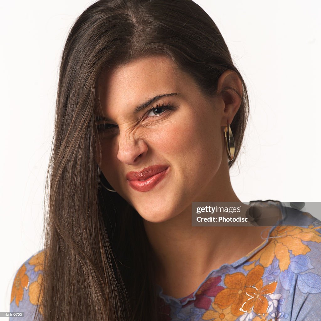 Portrait of a young attractive caucasian woman as she wrinkles her nose and smirks at the camera
