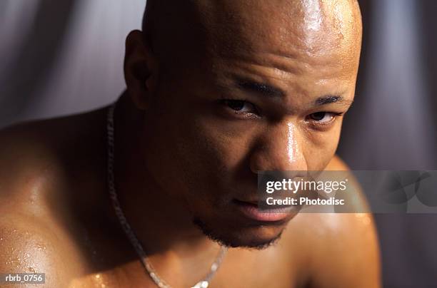 portrait of a young african american man with no shirt as he looks sternly into the camera - no fotografías e imágenes de stock