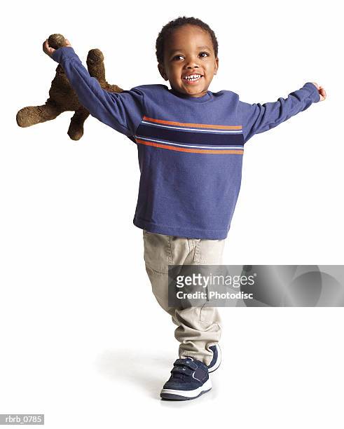 silhouette of an african american little boy in  a blue shirt as he runs with his teddy bear - runstudio stock pictures, royalty-free photos & images