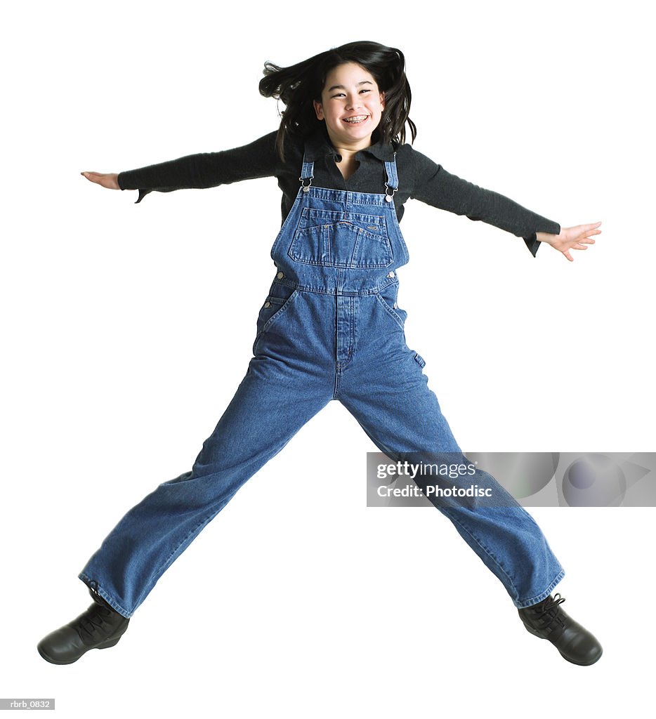 Silhouette of an asian teenage girl in denim overalls as she jumps up into the air