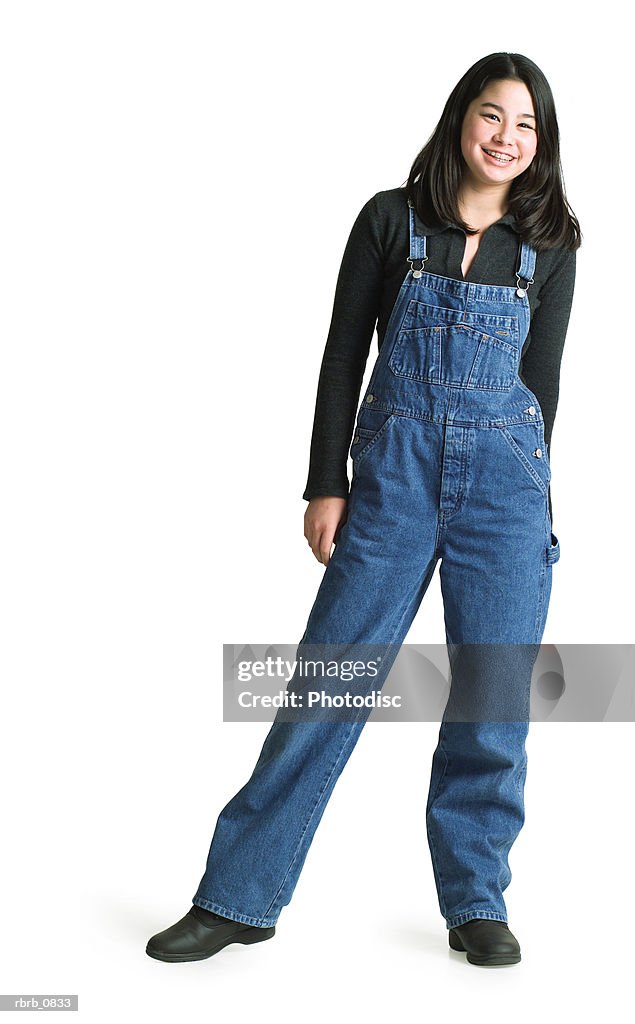 Silhouette of an asian teenage girl in denim overalls as she smiles at the camera