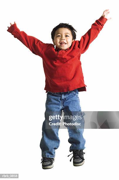 silhouette of an asian male child in jeans and a red shirt as he hops up into the air - asian male dancer stock-fotos und bilder