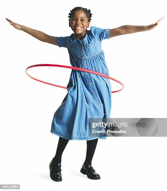 silhouette of an african american female child in a denim dress as she spins a plastic hoop around her waist - hooping stock pictures, royalty-free photos & images