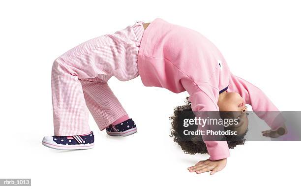 a cute little african american girl in a pink outfit flips herself upside down while playing - bending over backwards stock pictures, royalty-free photos & images