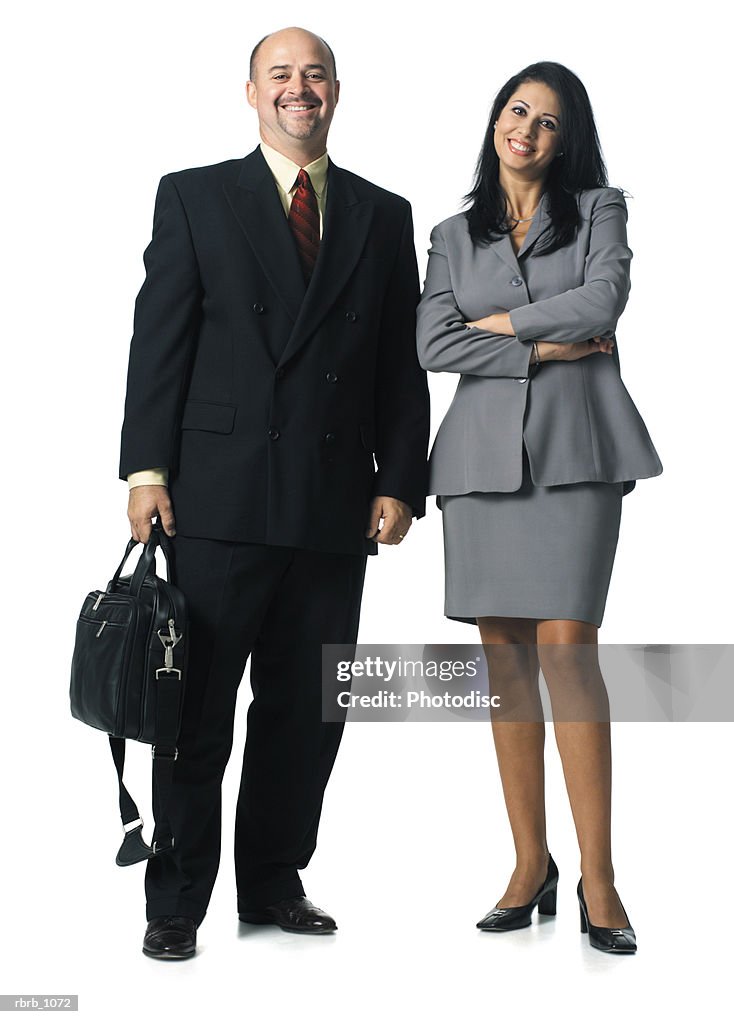 A caucasian business man and an ethnic business woman stand together smiling