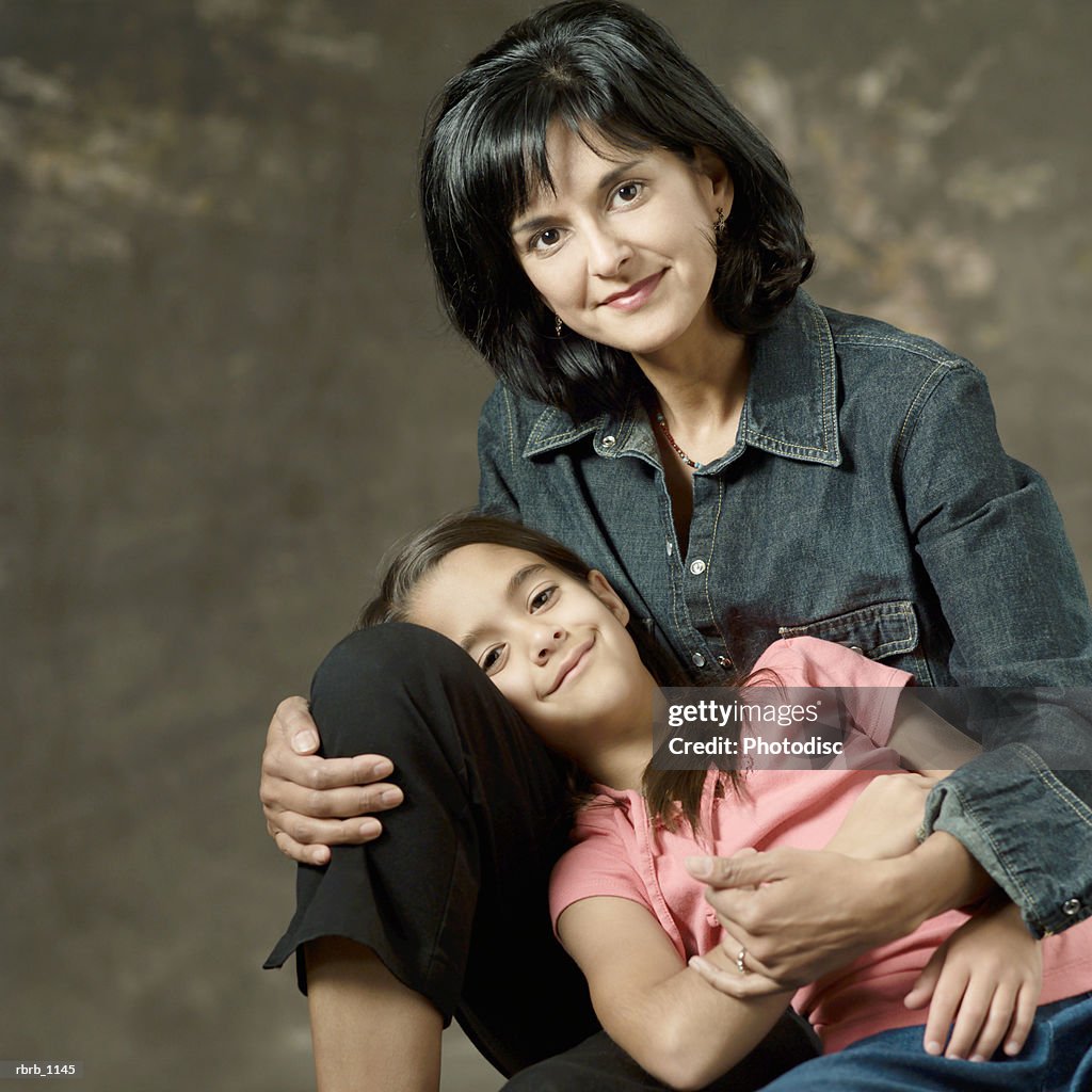 Portrait of an ethnic mother and daughter as the child lays across her mothers lap