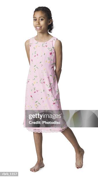 a young african american female child in a pink dress and and bare feet smiles happily - bare stock-fotos und bilder