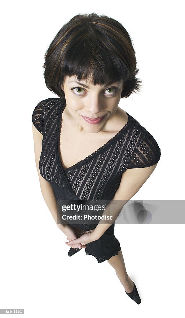 A young caucasian brunette woman in a black dress smiles up at the camera