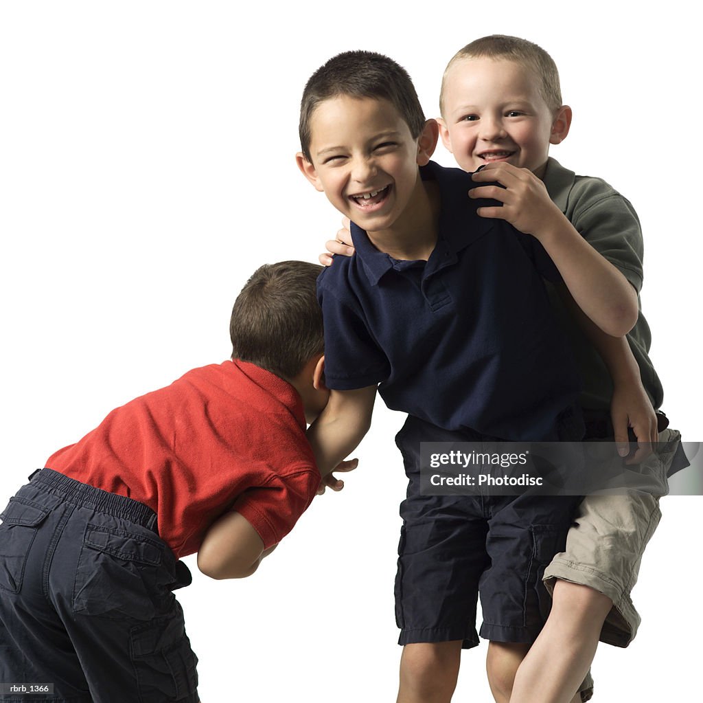 Three caucasian child brothers play and fight with each other