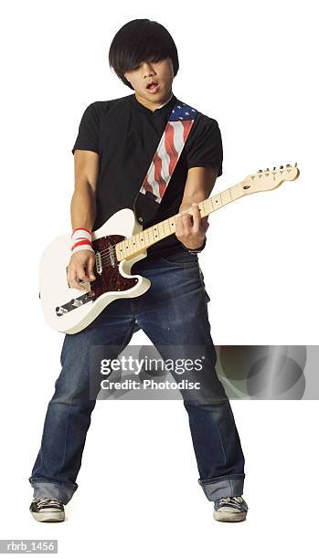 an asian teenage male in jeans and a black shirt plays his electric guitar - moderne rockmusik stock-fotos und bilder
