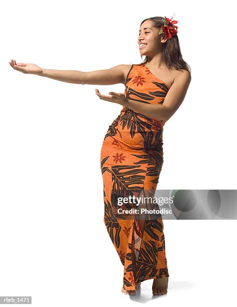 a polynesian teenage female in an orange floral dress does a traditional dance - ot ストックフォトと画像