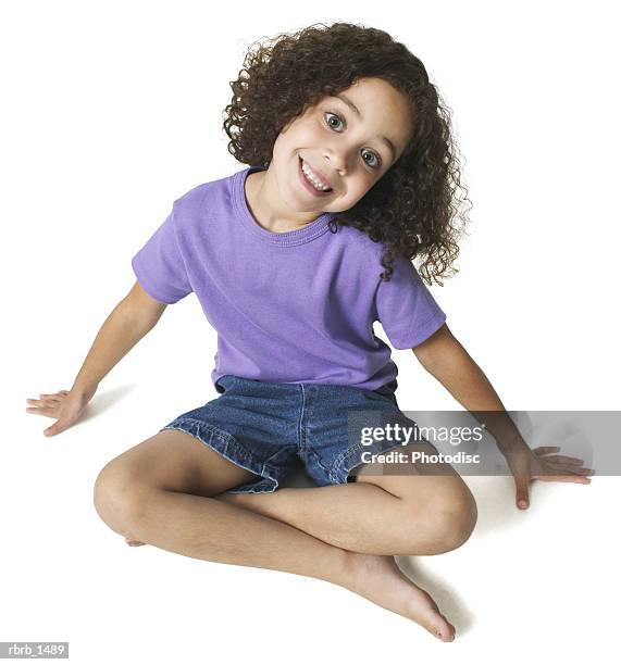 an ethnic female child in a purple shirt leans back and flashes a cute smile - smile stock-fotos und bilder