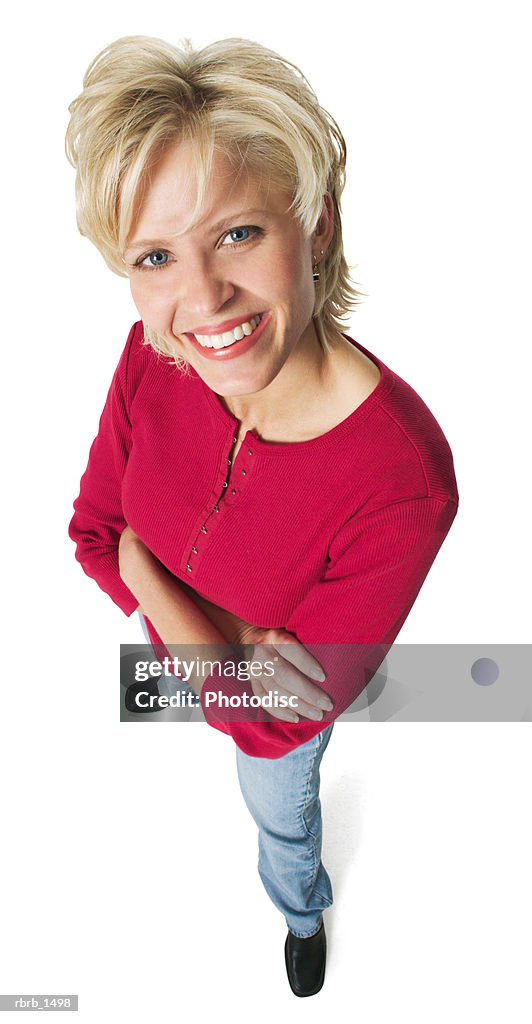 An attractive caucasian blonde woman in jeans and a red shirt smiles up at the camera