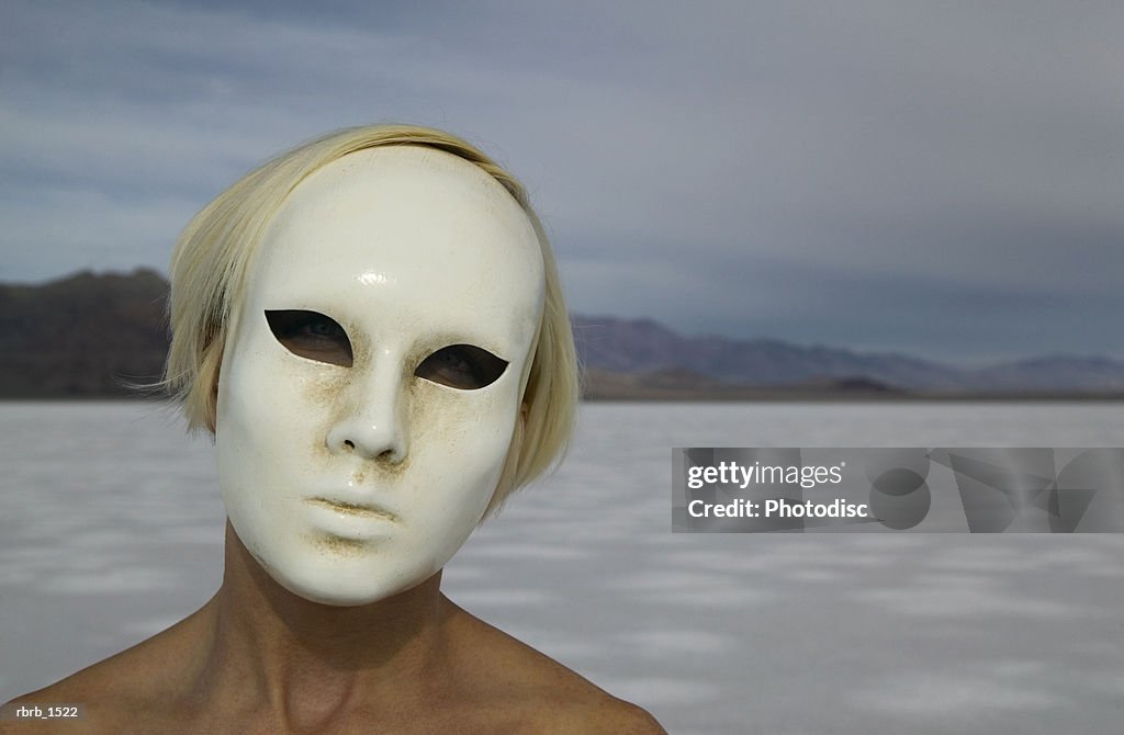 Abstract photograph of a woman in an odd mask in the middle of nowhere