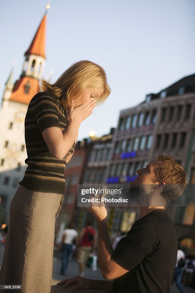 A young caucasian man propose marriage to his girlfriend while on vacation in europe