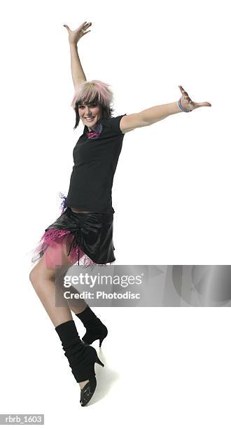 a young caucasian woman in a retro punk outfit strikes a fun dance pose - funky foto e immagini stock