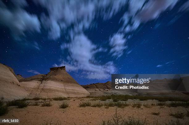 landscape photograph of the night sky appearing and clouds racing in a southwest setting - night in fotografías e imágenes de stock