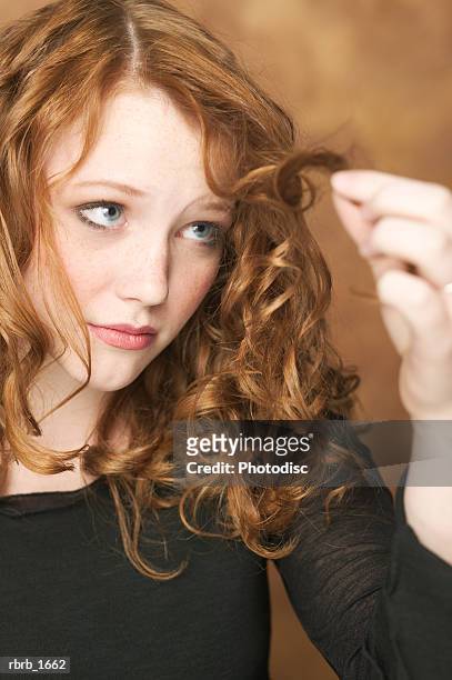 portrait of a female redheaded teen in a black shirt as she examines the end of her curls - world premiere of the end of longing written by and starring matthew perry stockfoto's en -beelden
