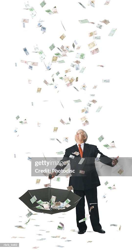 Conceptual photograph of a business man as he catches raining euros in his umbrella