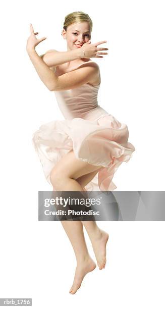 a caucasian blonde female teen in a pink ballet outfit jumps up and smiles - ot ストックフォトと画像