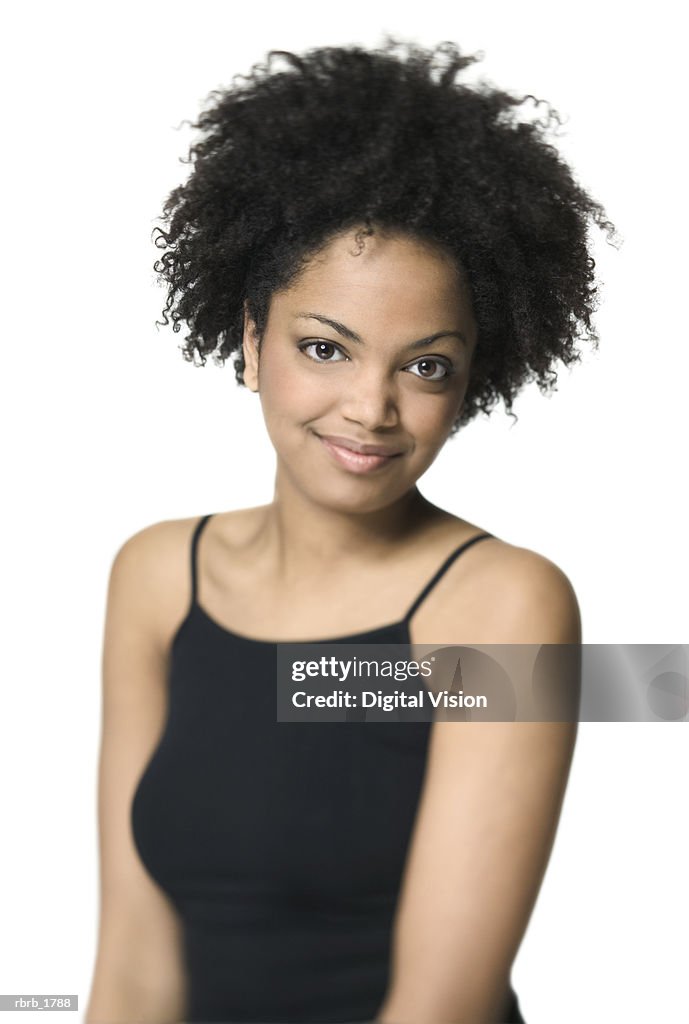 Medium shot of a young adult woman in a black tank top as she smiles