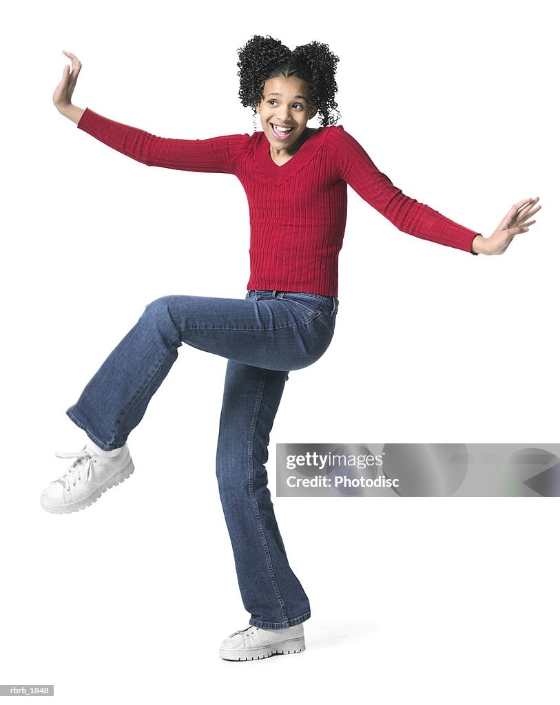 Full body shot of a female child in a red sweater as she dances playfully