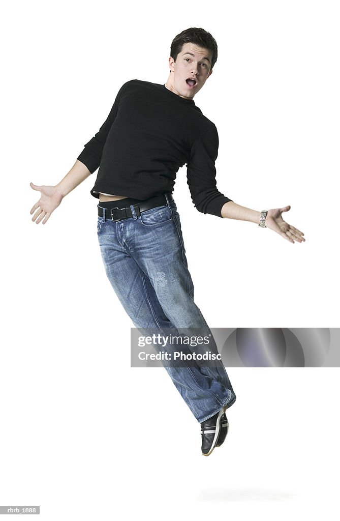 Full body shot of a young adult male in a black shirt as he playfully jumps up