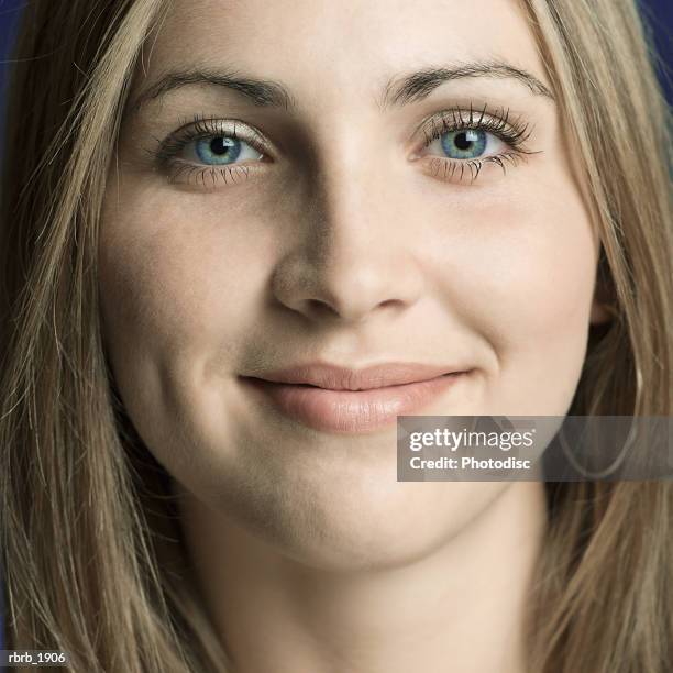 close up portrait of a blonde teenage girl as she flashes a slight smile - smile stock-fotos und bilder