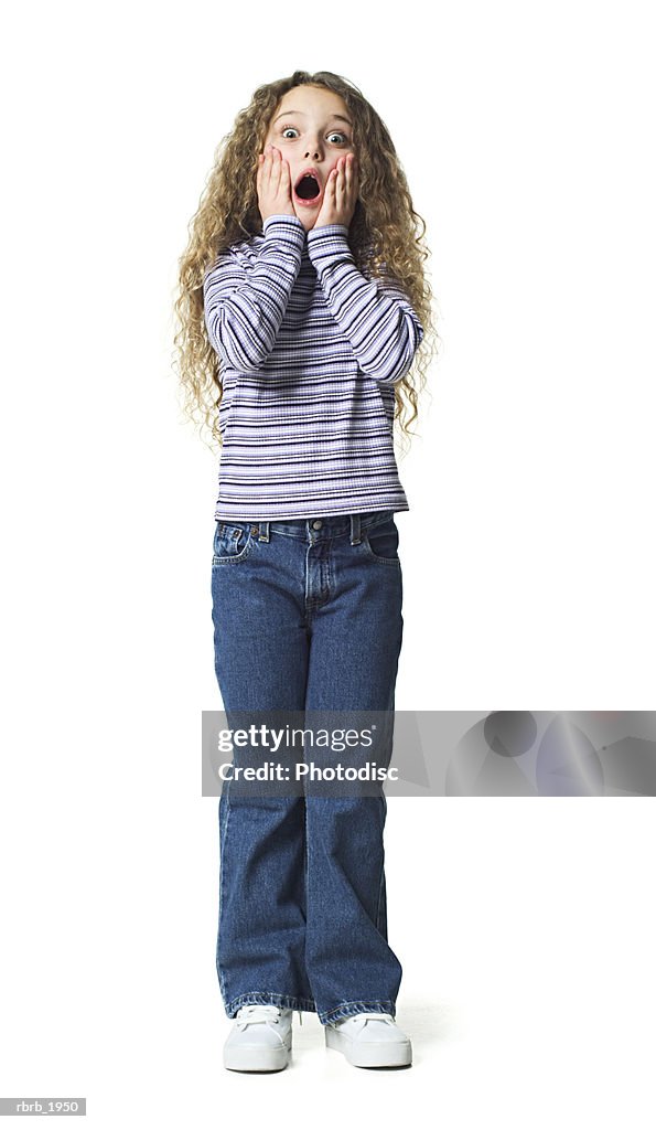Full body shot of a female child in striped shirt she puts her hands to her face and acts surprised
