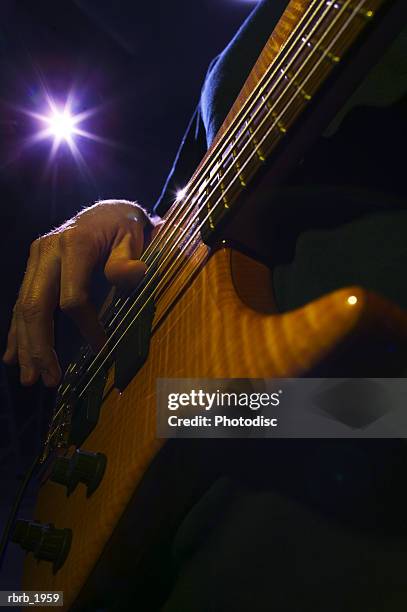 close up shot of a bass guitar as it is played up on stage - moderne rock stockfoto's en -beelden