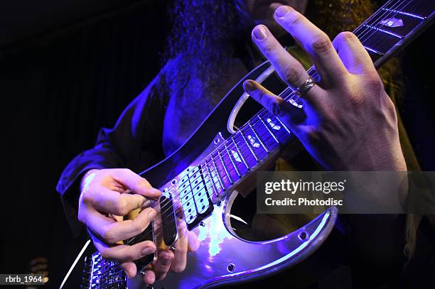 close up shot of an electric guitar as it is played up on stage - moderne rockmusik stock-fotos und bilder