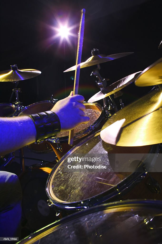 Close up shot of a set of hands as they play the drums up on stage